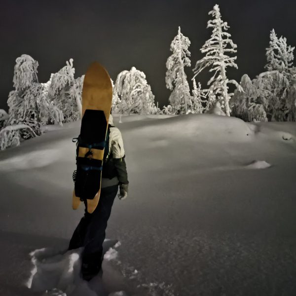 Snowsurfer climbing uphill at night. Link takes you to evening snowsurfing section in tour-page